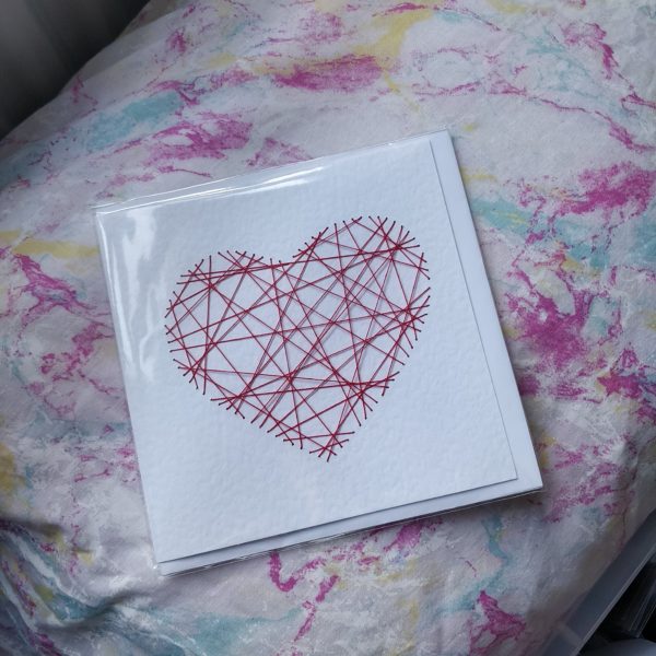 Square Card with a red threaded design in the shape of a heart