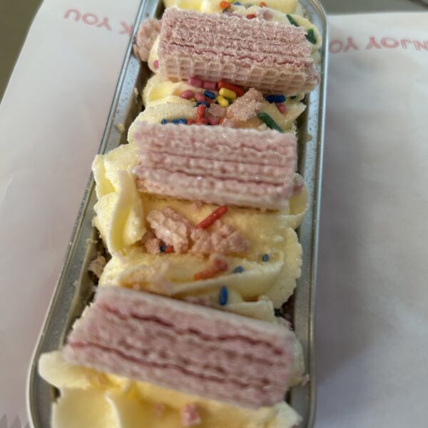 A tray bake cake decorated with pink wafers