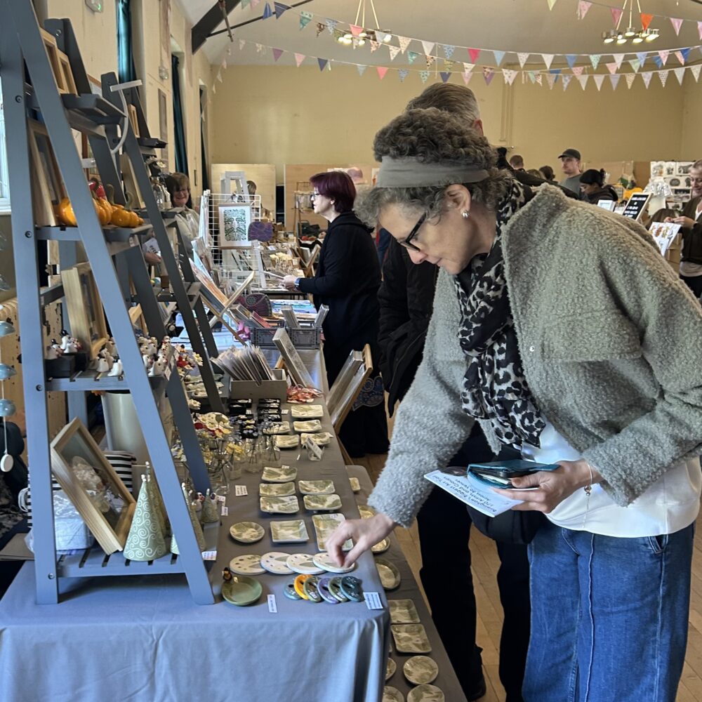 Harborne Handmade - A woman looks at ceramics on a stall