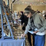 A woman looks at ceramics on a stall
