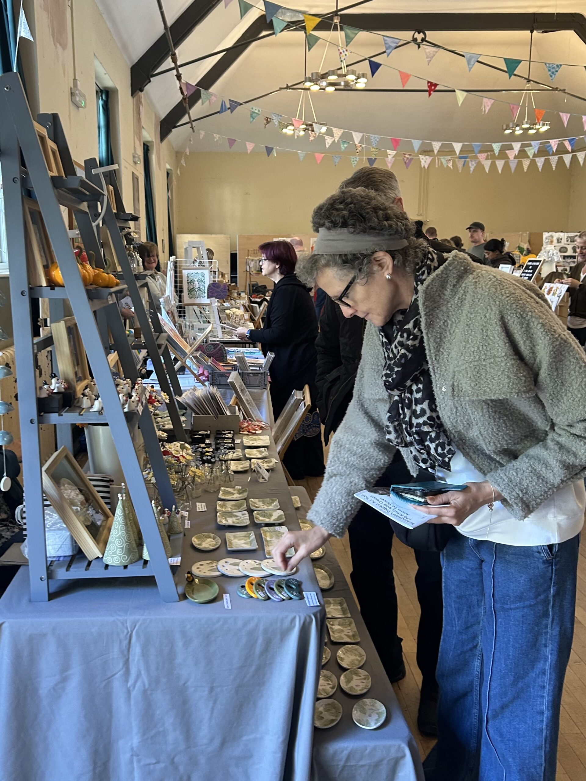 A woman looks at ceramics on a stall