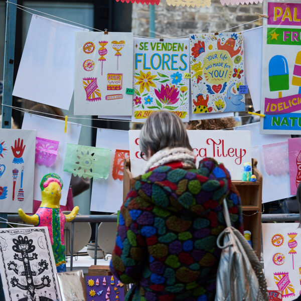 Shopper browsing colourful market stall. Crafty Fox Market