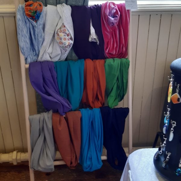 hanging rail displaying a number of different coloured scarves