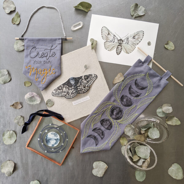 A variety of moon and moth themed papercuts, watercolours, paper sculptures, and embroidery