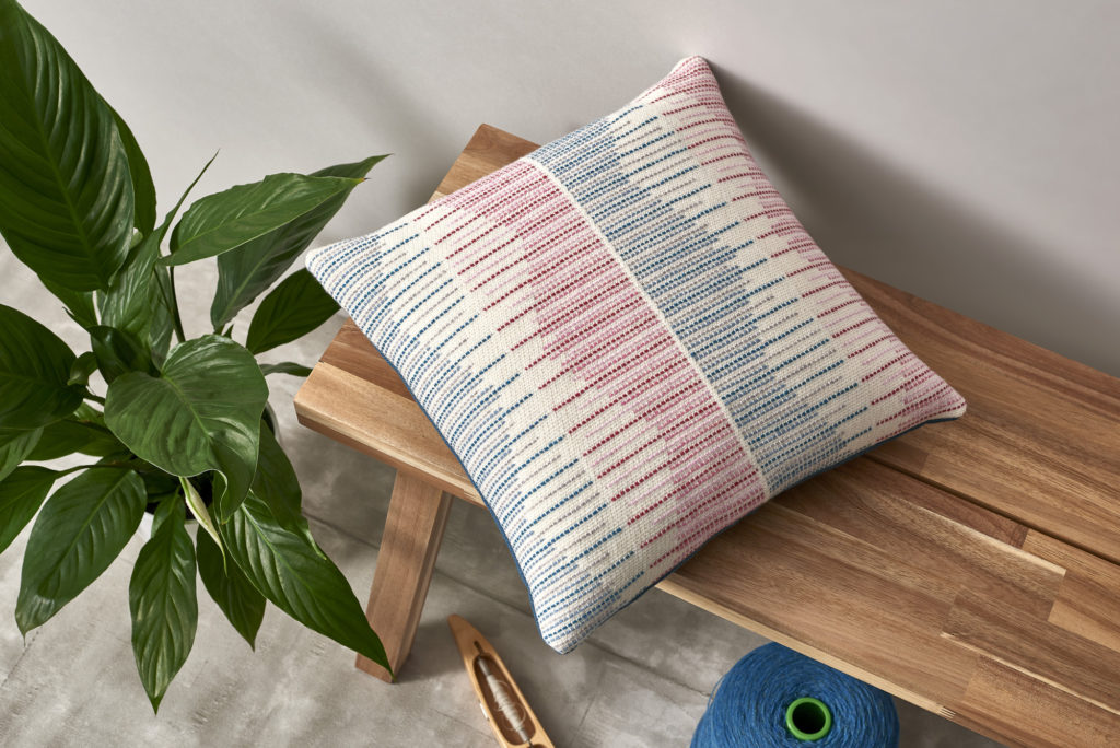 Hand-woven merino throw cushion in pink and blue