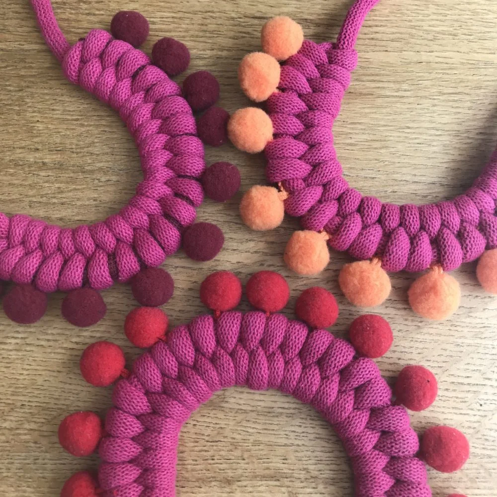Loups, Pompom necklaces in hot pink, reds and orange