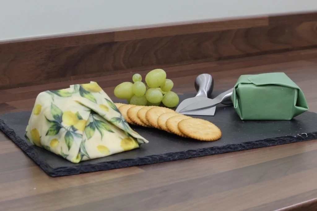 Sweet Bee Wraps UK green and lemon wax wrapped cheese board with grapes and crackers - live a more sustainable lifestyle