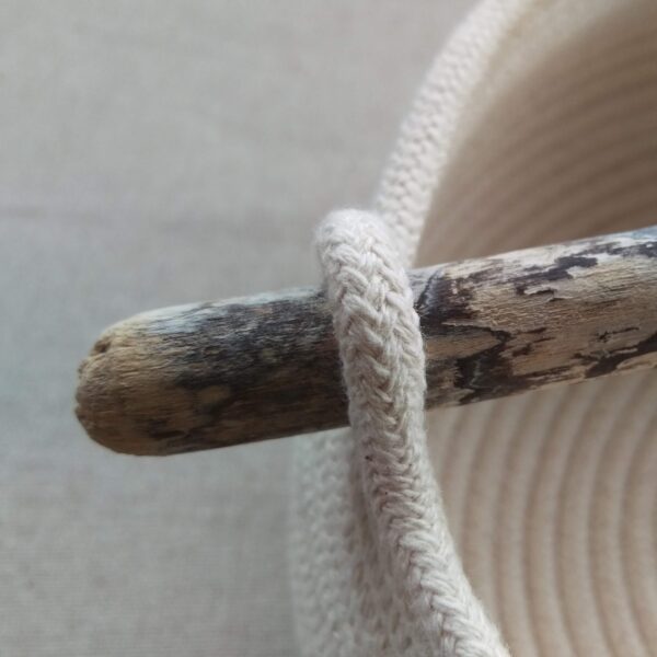 Close up of the end of a driftwood handle on a coiled rope bowl