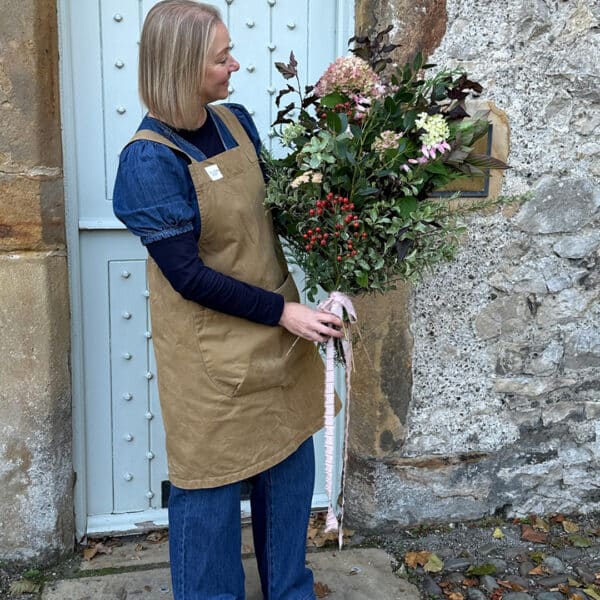 Tracey from wild soul flowers holding a sheaf arrangement