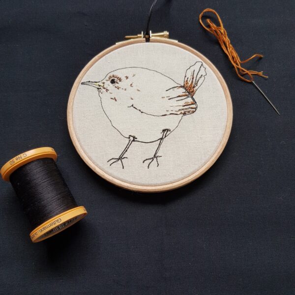 Gemma Rappensberger embroidered illustration of a Jenny Wren Bird using free motion machine embroidery in black cotton with hand embroidery details on calico in a beech wooden embroidery hoop