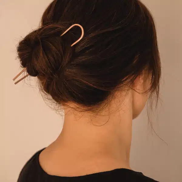 copper hair fork worn in a low bun hairstyle – minimal handmade hair accessory."