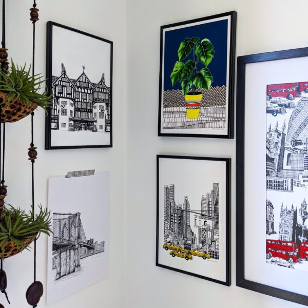 Katie Clement Illustration, Art Print Gallery wall featuring framed Liberty of London, Monstera, Times Square and London Skyline Prints and an unframed Brooklyn Bridge print