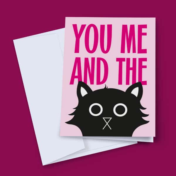A pink card with the text "You Me And The" in bold pink letters. A black cat with white eyes peeks out from below the text.