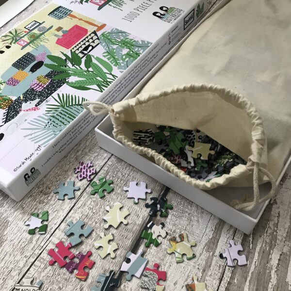 Photograph Shows An Opened Jigsaw Puzzle With Pieces On The Table and Cloth Bag With Puzzle Pieces - Jigsaw Designed By Sister Sister And Titled Ssshhh - 1000 Piece Jigsaw Puzzle