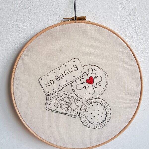 Gemma Rappensberger Biscuits illustration free motion machine embroidery in black thread with red hand embroidery on calico in a 9" wooden hoop