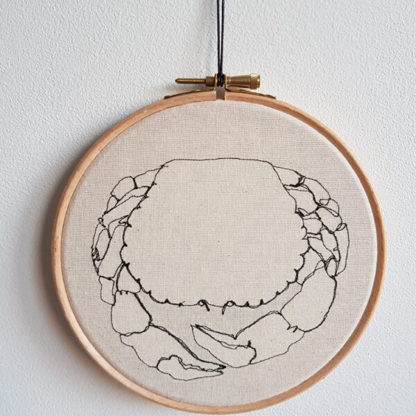 Gemma Rappensberger Crab illustration using free motion machine embroidery in black thread on calico displayed in a 6" wooden embroidery hoop