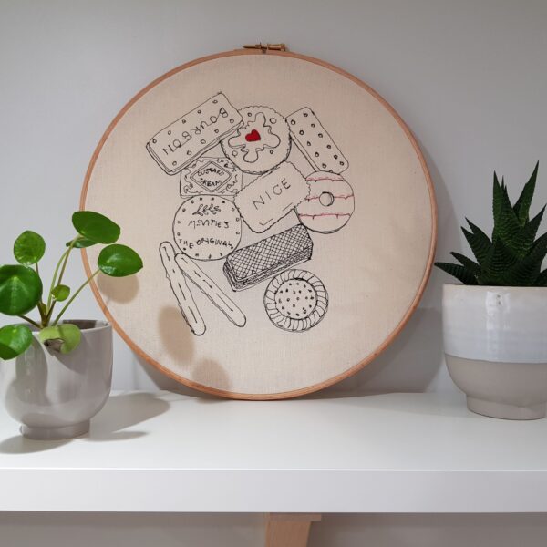 Gemma Rappensberger Teatime Treats embroidered illustration using free motion machine embroidery of favourite teatime biscuits in black cotton thread with hand embroidery details on calico in a 12" wooden embroidery hoop