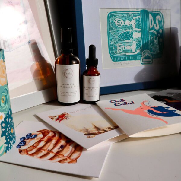 A selection of Brown Paper Festival stallholder products including greeting cards, facial oils and art