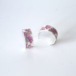 Fine silver half hoops handmade earrings with purple resin flower details.