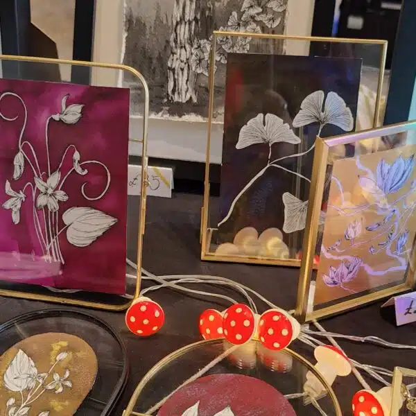 Art stall displaying framed artwork with a mix of different trees and flowers
