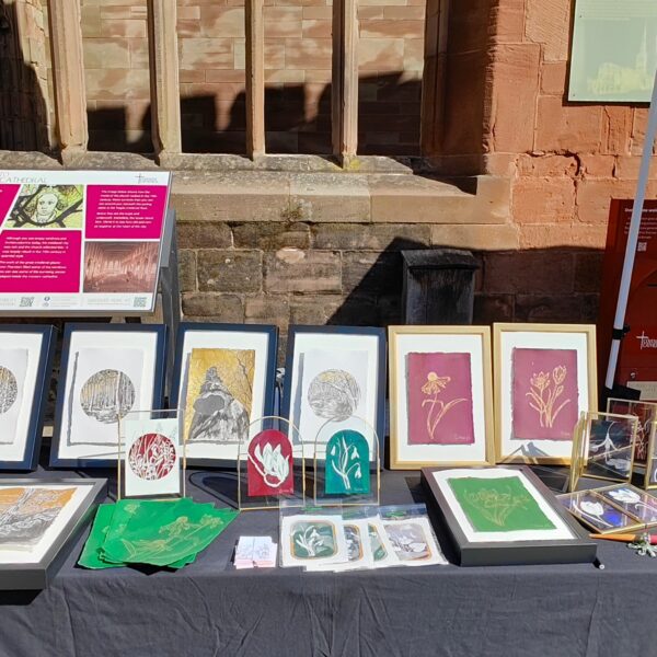 Art stall displaying framed artwork with a mix of different trees and flowers