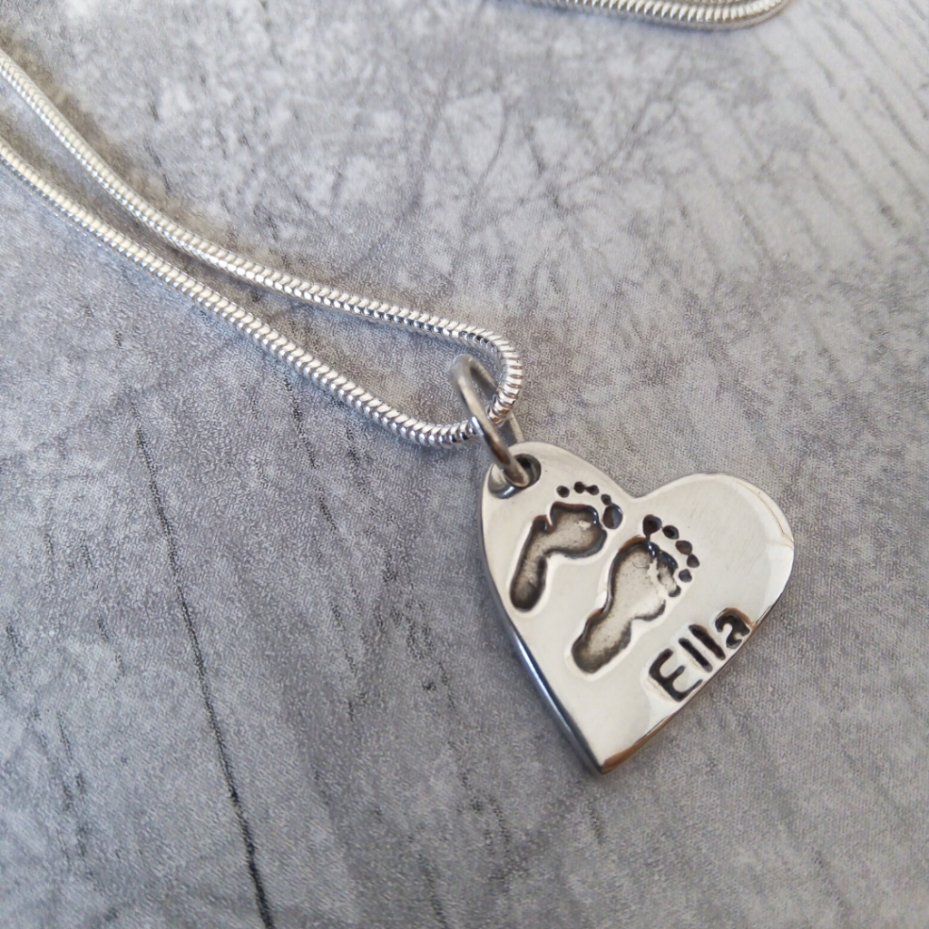 true love keepsakes, heart footprint charm necklace made from pure silver personalised with a name attached to a snake chain