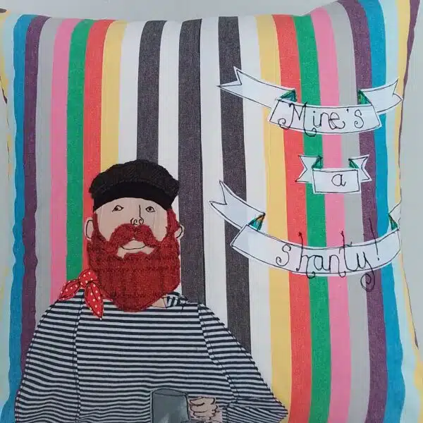 Mae-Kandoo-Cushion -bearded - Shanty-singer- appliqued onto a multicoloured stripe background