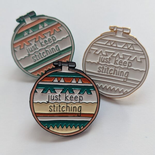 Little Light Stitchery enamel pins. three pins each with the quote just keep stitching on a stripy geometric background. Bright, pastel and white gold colourways