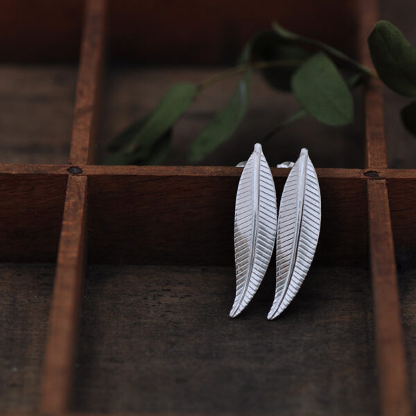 Upside Down Tree Studio, silver willow leaf earrings in a compartment with green foliage