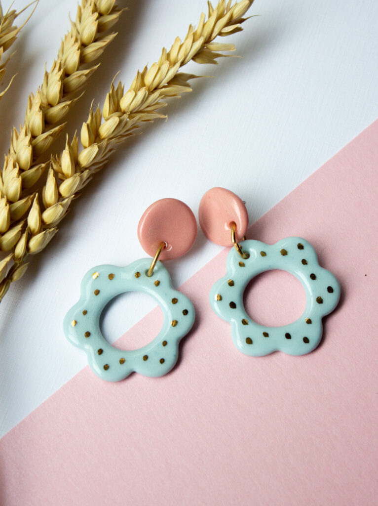 Blue flower shapes attached to pink circles. Earrings by Helen Manterfield.