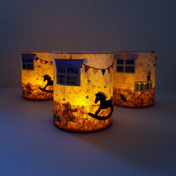 PeachTreePig - A collection of three handcrafted nursery playroom LED lanterns with the candles lit (© PeachTreePig)