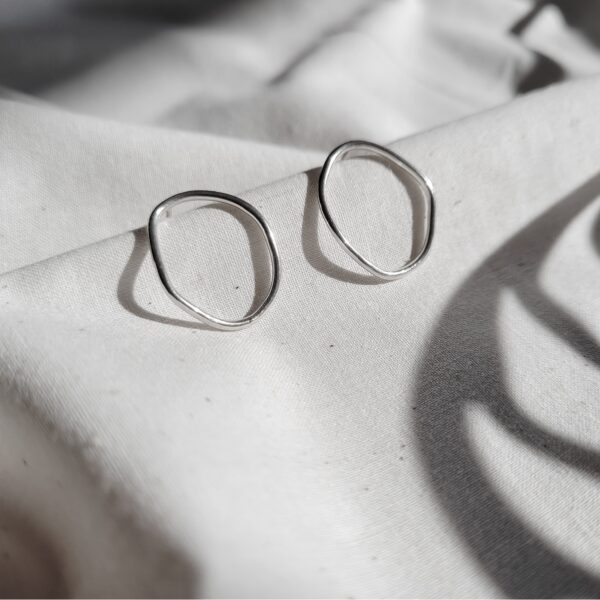 KiJo Jewellery: Organic Circle Silver Stud Earrings on natural fabric crease with spiral shadows