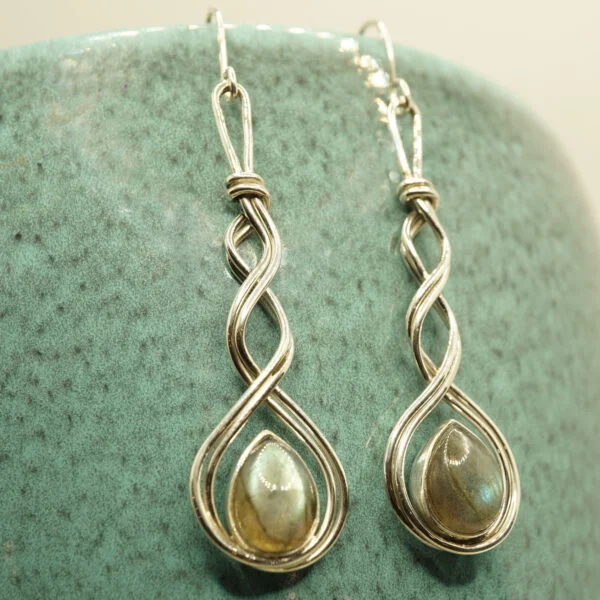 The Silver Bird Bezel set labradorite gemstone drop earrings with twisted wire surround hanging from green plant pot
