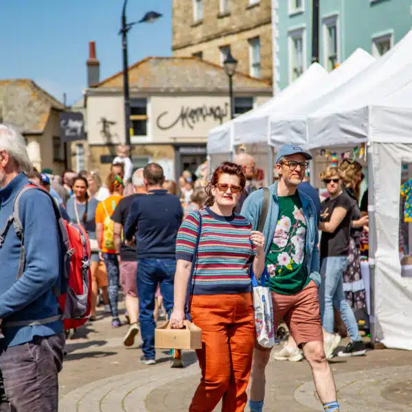 People shopping and walking through a street market in Truro