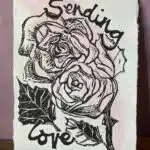 Mandy Benton Printmaker, 'Sending Love' Linocut Print. A small linocut print on a beautiful handmade paper depicting roses and the message 'Sending Love'. Printed in black ink over a sweep of pink watercolour paint.