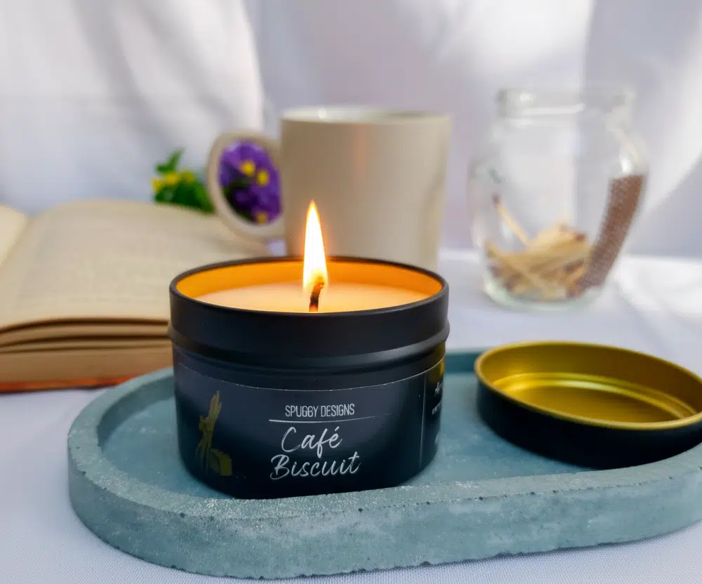 Café Biscuit Soy Wax scented candle, lit on a ceramic dish.