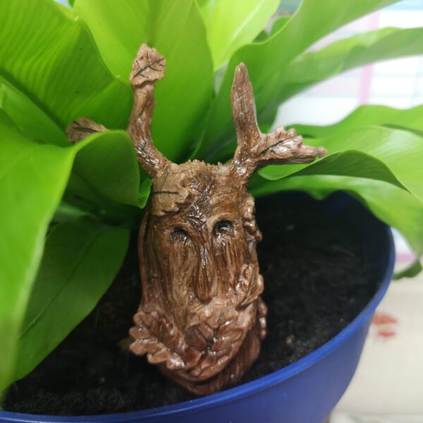 Bythecrookofmyhook. Terracotta anthropomorphic tree spirit nestled in a plant pot.