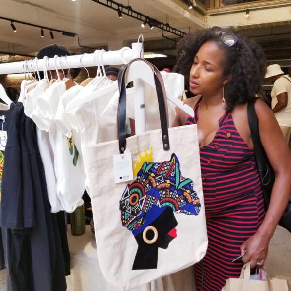 Black Culture Market, London. Lady looking at a tote bag.
