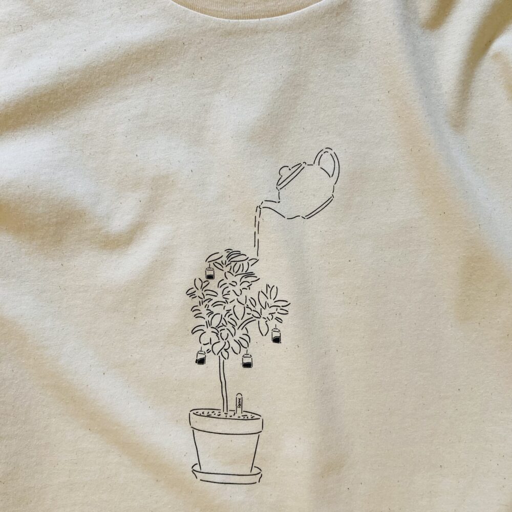 Natural t-shirt featuring a plant blooming tea bags and a tea pot watering the plant