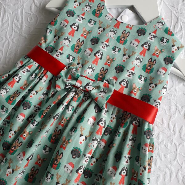 Christmas dress in green premium cotton, has small puppies wearing Christmas hats and scarves. Available in sizes 12 months to 5 years, by Audrey's Attic