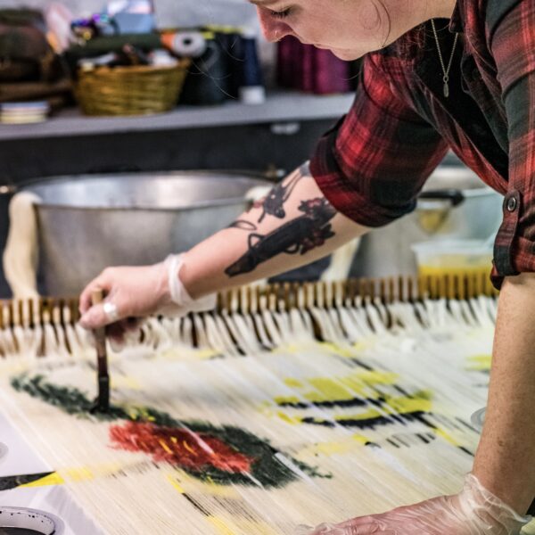 Fruitbat Textiles, Charlotte hand painting a British wool warp