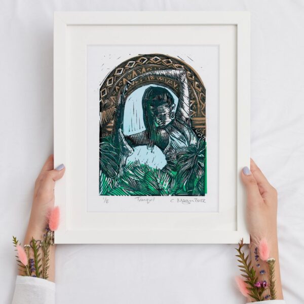 hands holding a 8x10 inch linocut print in a white frame. yoga figure stretching in nature. green and gold.