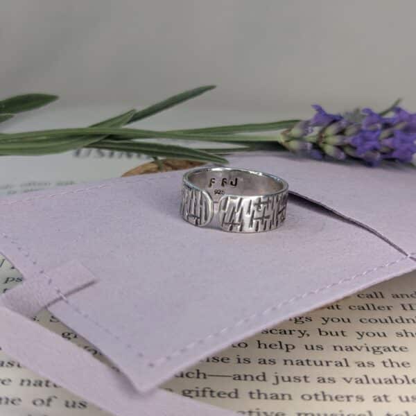 Silver ring on a purple fabric background with lavender flowers