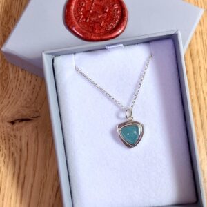 This is a sterling silver pendant set with a lovely bluey green aquamarine trillion cabochon. The aquamarine is approximately 8mm diameter and is a lovely milky blue-green colour. It is set in an asymmetrical silver bezel and I have given it a shiny polished finish. Nicole Jansen Jewellery