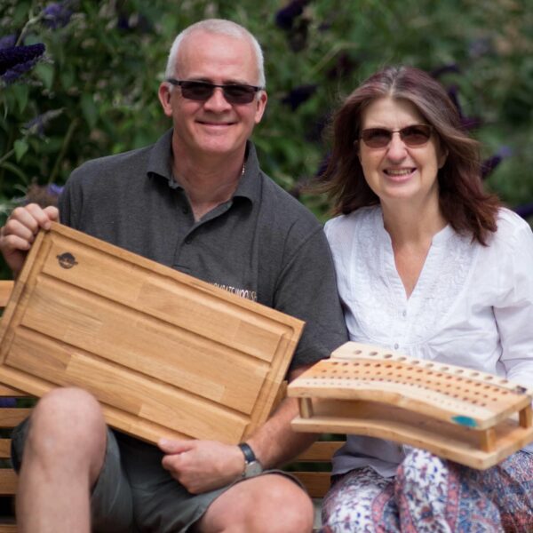 Bill & Carol Webb are Wombats Woodshop, with a large grooved chopping board and crochet hook stand