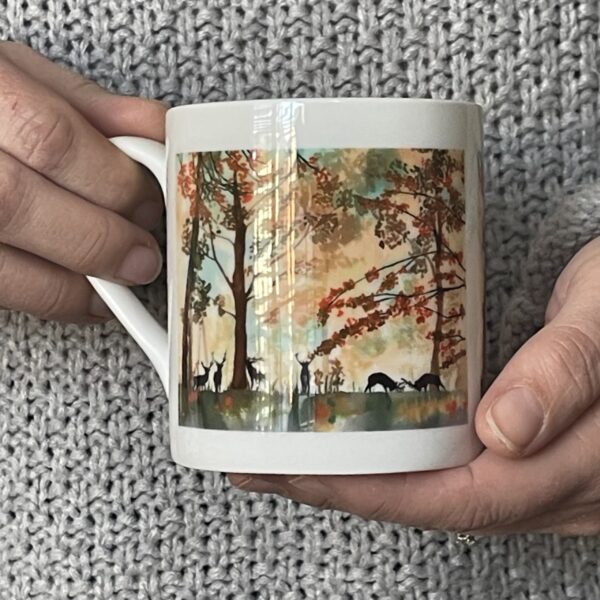 a bone china mug with an autumnal picture of trees and deer