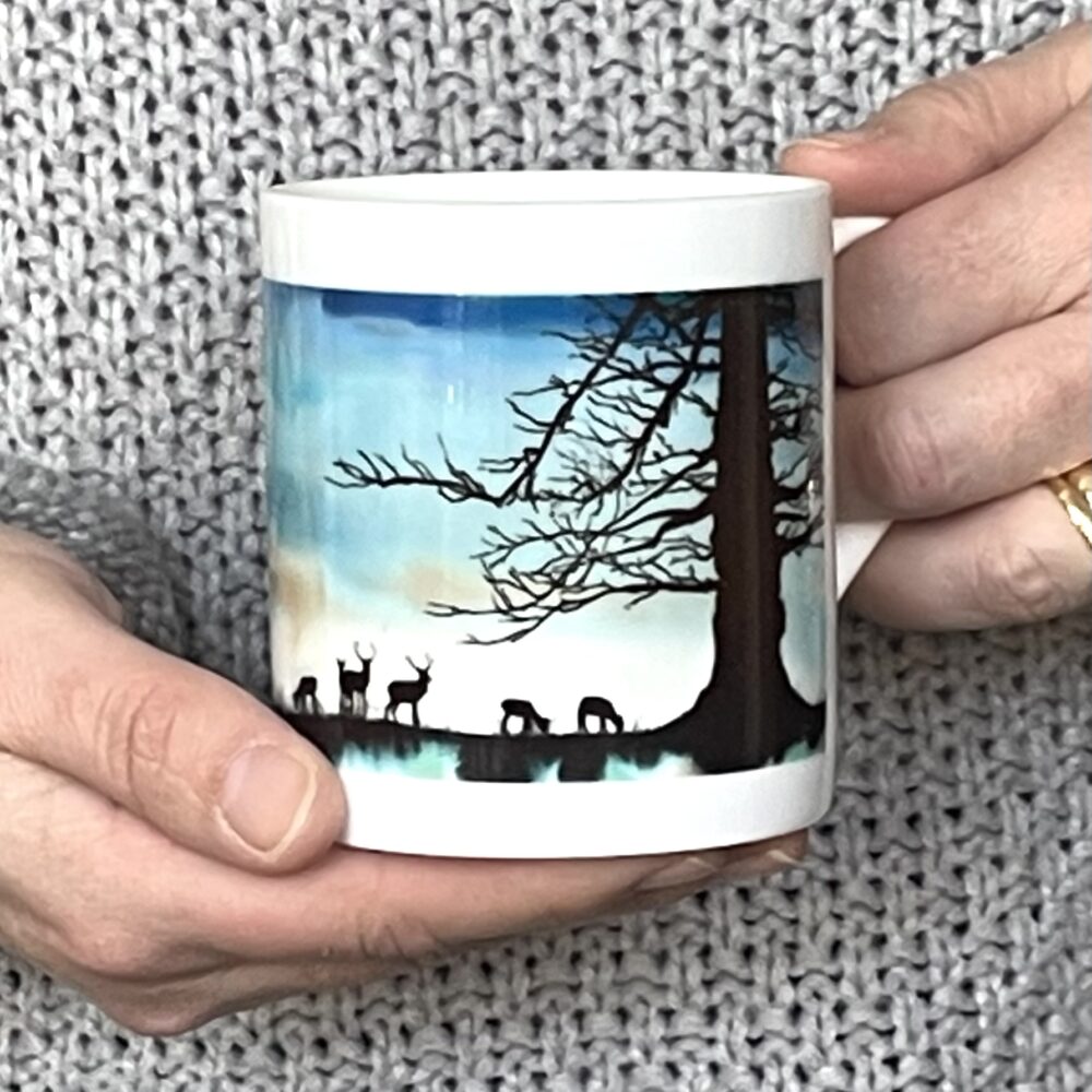 Squiggly Sue Designs 'Branching Out' Bone China 8oz Mug a blue sky with trees and deer in silhouette