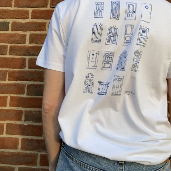 White t-shirt featuring a back print of 16 different hand drawn doors, printed in a navy blue ink