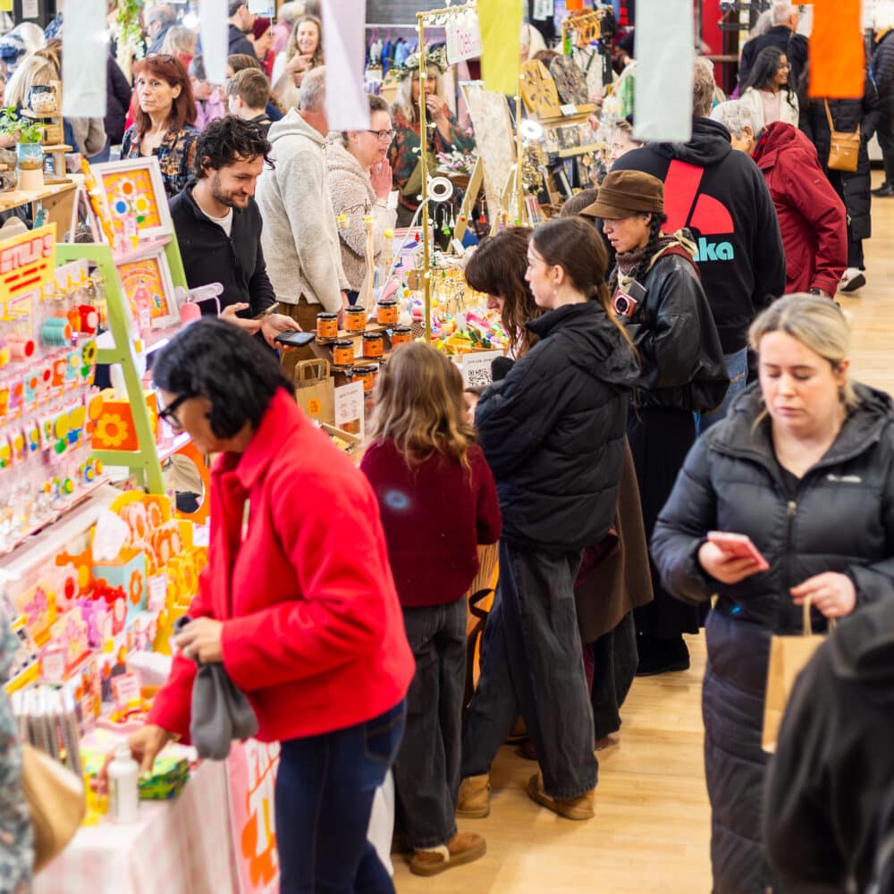 Crowds browsing colourful independent maker stalls at a busy Paper Daisy Events makers fair at The Shoreham Centre in Shoreham.