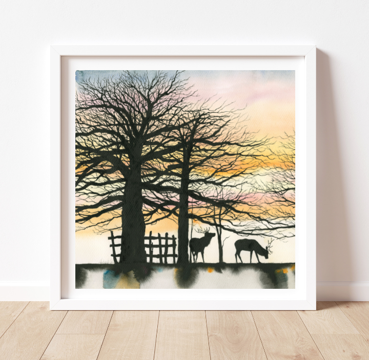 a square painting in a white frame with a colourful sky, several trees, a fence and stags in silhouette